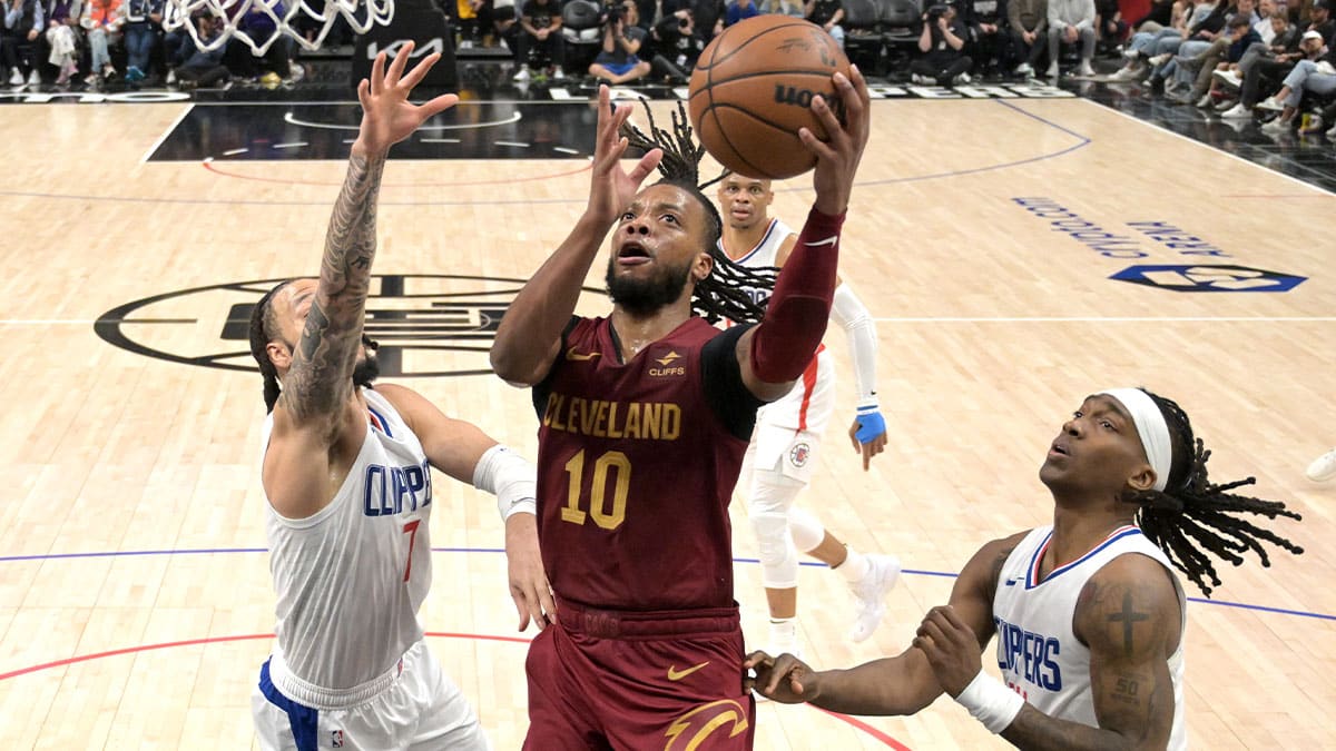 Cleveland Cavaliers guard Darius Garland (10) drives past Los Angeles Clippers guard Amir Coffey (7) and guard Terance Mann (14) in the second half at Crypto.com Arena. 