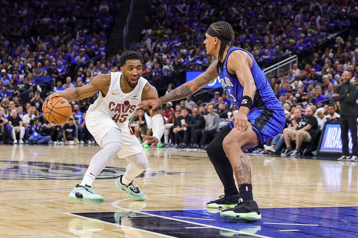 Cleveland Cavaliers guard Donovan Mitchell (45) handles the ball against Orlando Magic forward Paolo Banchero (5) during the second half of game six of the first round for the 2024 NBA playoffs at Kia Center.