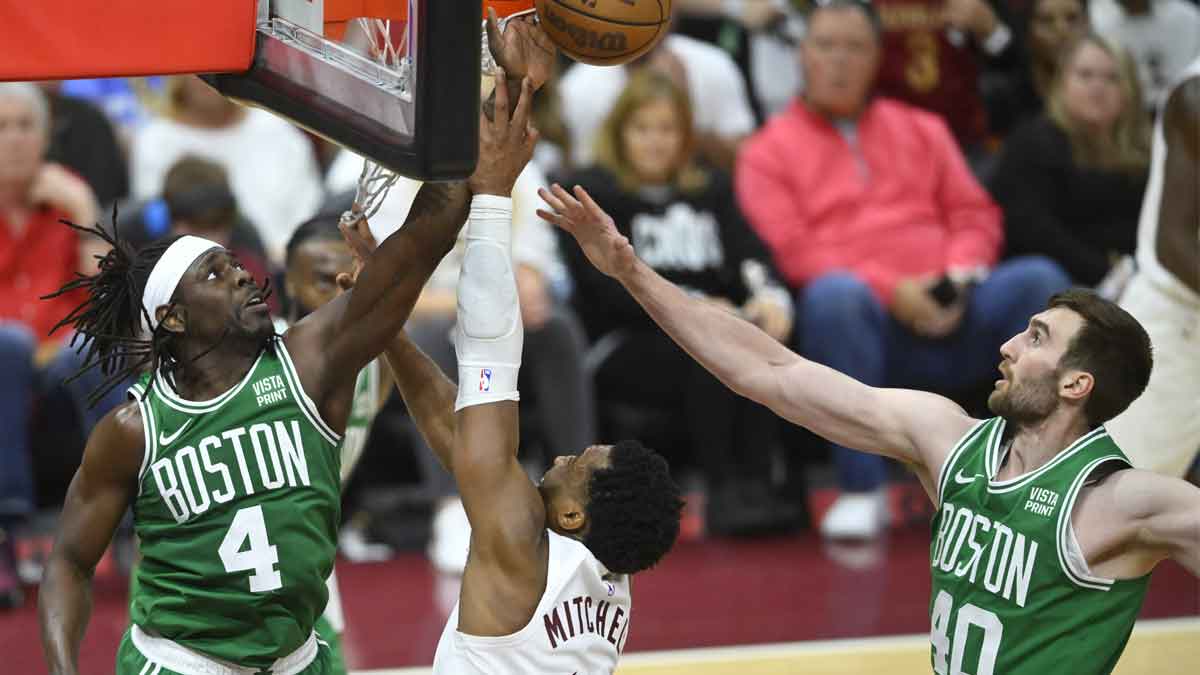 May 11, 2024; Cleveland, Ohio, USA; Cleveland Cavaliers guard Donovan Mitchell (45) shoots the ball against Boston Celtics guard Jrue Holiday (4) and center Luke Kornet (40) in the third quarter of game three of the second round of the 2024 NBA playoffs at Rocket Mortgage FieldHouse. Mandatory Credit: David Richard-USA TODAY Sports