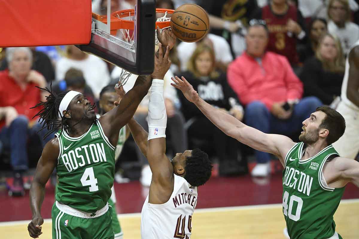 May 11, 2024; Cleveland, Ohio, USA; Cleveland Cavaliers guard Donovan Mitchell (45) shoots the ball against Boston Celtics guard Jrue Holiday (4) and center Luke Kornet (40) in the third quarter of game three of the second round of the 2024 NBA playoffs at Rocket Mortgage FieldHouse. Mandatory Credit: David Richard-USA TODAY Sports