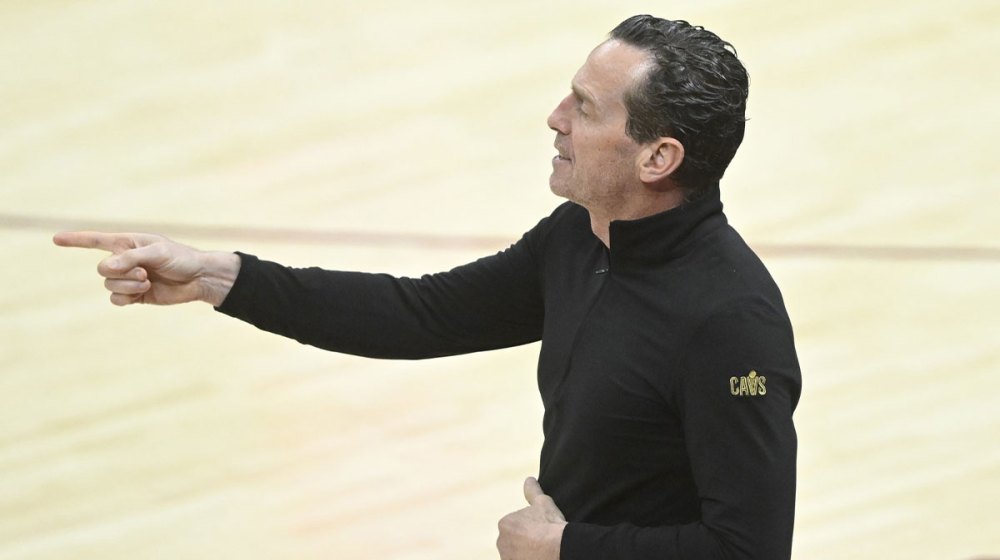 Cavs head coach Kenny Atkinson next to Cavs logo