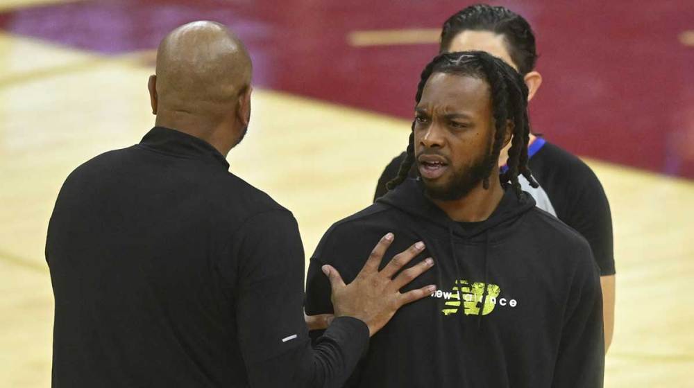 Detroit Pistons head coach J.B. Bickerstaff and Cleveland Cavaliers guard Darius Garland (10) stand near center court during a timeout in the fourth quarter at Rocket Arena.