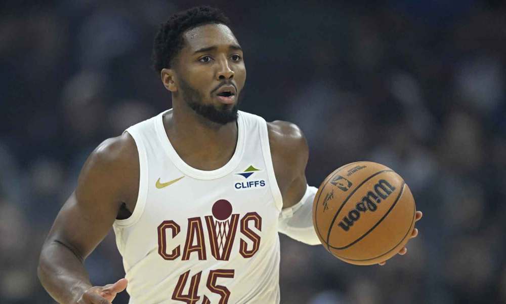 Cavaliers guard Donovan Mitchell (45) brings the ball up court in the first quarter against the Toronto Raptors at Rocket Arena with the Celtics logo in the background