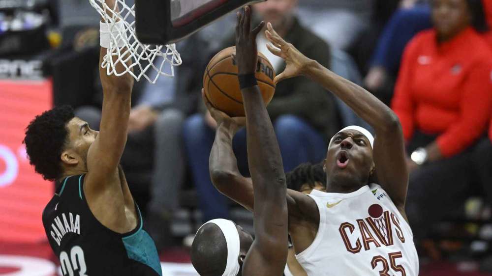 Cleveland Cavaliers forward Nae’Qwan Tomlin (35) shoots against Portland Trail Blazers forward Toumani Camara (33) and center Duop Reath (26) in the third quarter at Rocket Arena.
