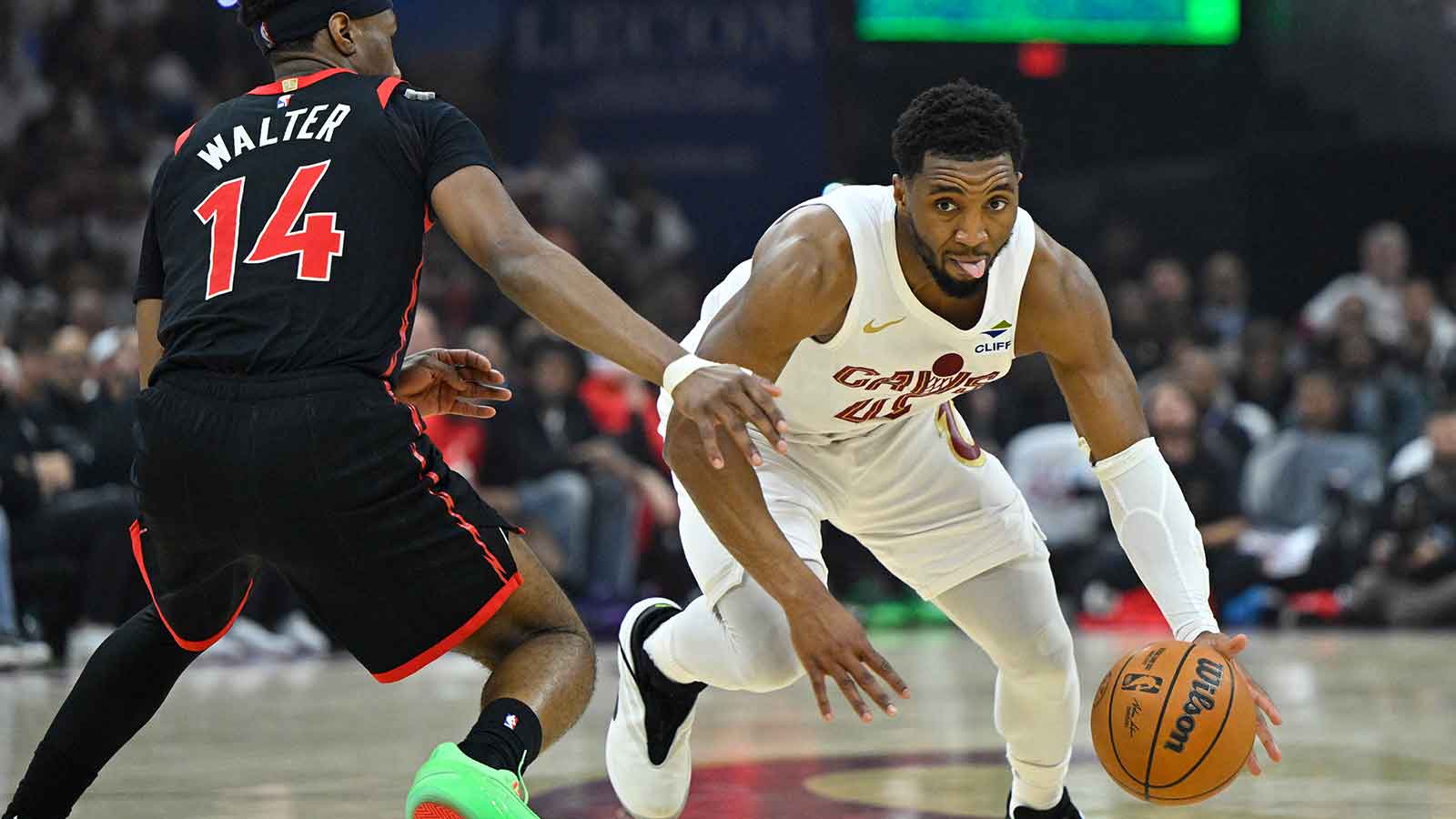 Cleveland Cavaliers guard Donovan Mitchell (45) dribbles beside Toronto Raptors guard Ja'Kobe Walter (14) in the third quarter of game five of the first round of the 2026 NBA Playoffs at Rocket Arena.