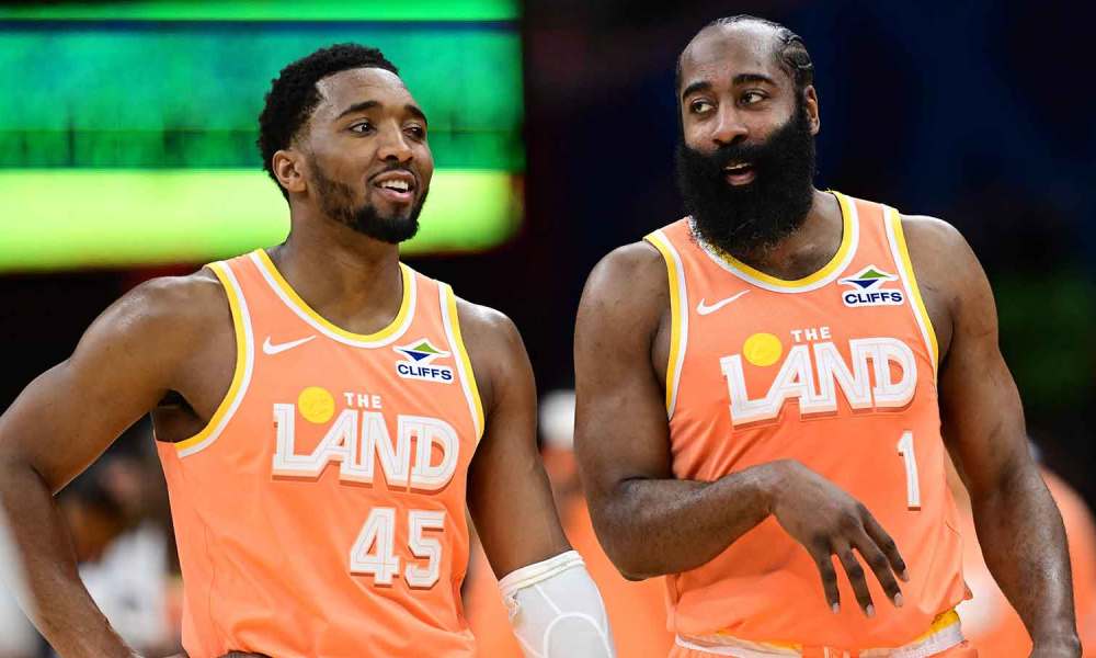 Cleveland Cavaliers guard Donovan Mitchell (45) and guard James Harden (1) talk during a free throw attempt during the second half against the Orlando Magic at Rocket Arena with Cavs 2026-27 and the Knicks logo in the background