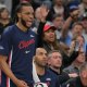 Clippers guard Darius Garland (10) reacts on the bench after a basket in the first half against the Golden State Warriors during the play-in rounds of the 2026 NBA Playoffs at Intuit Dome with the Cavs logo in the background