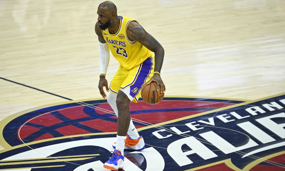 Los Angeles Lakers forward LeBron James (23) brings the ball up court in the fourth quarter against the Cleveland Cavaliers at Rocket Arena with Stephen A Smith in the background