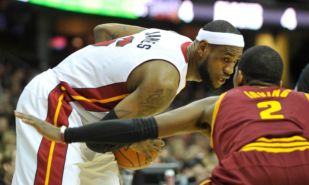 Miami Heat small forward LeBron James (6) holds the ball in front of Cleveland Cavaliers point guard Kyrie Irving (2) in the third quarte at Quicken Loans Arena.