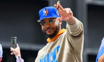 Knicks guard Carmelo Anthony waves to the crowd during the New York Knicks Championship Parade through the Canyon of Heroes with Cavs' Meleek Thomas in the background